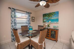 a dining room with a table and chairs and a fan at Waves 8 in St Pete Beach