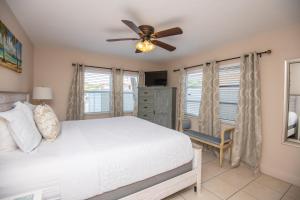 a bedroom with a bed and a ceiling fan at Waves 8 in St Pete Beach +61 photos