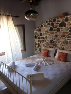a bedroom with a large bed with a stone wall at Stone and Serenity Cottage in Pilion