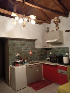 a kitchen with red and green cabinets and a sink at Stone and Serenity Cottage in Pilion
