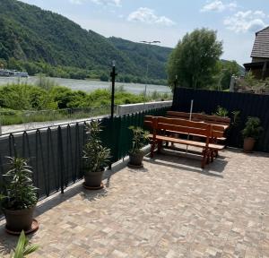 un patio con due panchine di legno e piante in vaso di HAUS-DONAU in der Wachau ad Aggsbach