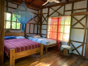 a room with two beds and a window at Casa de Colores in El Zonte +49 photos
