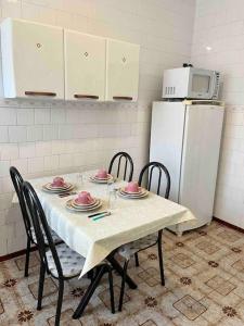 a kitchen with a table with chairs and a refrigerator at Apartamento Centro SerraNegra in Serra Negra