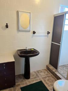 a bathroom with a sink and a shower at Apartamento Centro SerraNegra in Serra Negra