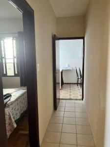 a hallway with a room with a bed and a table at Apartamento Centro SerraNegra in Serra Negra