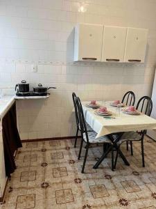 a kitchen with a table and chairs in a kitchen at Apartamento Centro SerraNegra in Serra Negra