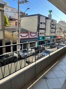 a balcony with cars parked on a city street at Apartamento Centro SerraNegra in Serra Negra