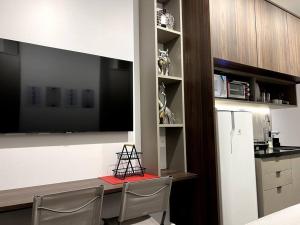 uma cozinha com uma mesa com 2 cadeiras e um frigorífico em Studio Especial Moema pra você! em São Paulo