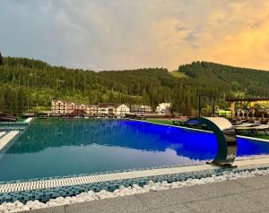 a large swimming pool with a mountain in the background at Gold Palace Bukovel in Bukovel