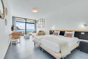 a bedroom with a large bed with a view of the ocean at Paradise Playa del Cura in Las Palmas de Gran Canaria +18 photos
