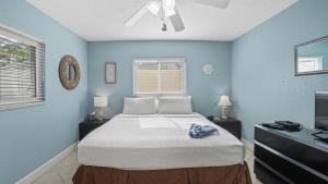 a blue bedroom with a bed and a television at Waves 1 in St Pete Beach +65 photos