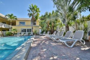 a row of chaise lounge chairs next to a swimming pool at Waves 1 in St Pete Beach