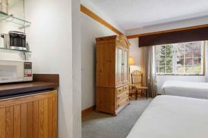 Dormitorio pequeño con cama y microondas en The Charter at Beaver Creek D315, en Beaver Creek