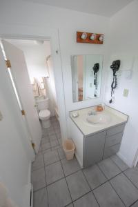 a white bathroom with a sink and a toilet at Eastwood at Provincetown in Provincetown