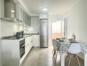 a kitchen with a table and a stainless steel refrigerator at Bright Place Bungalow in San Bartolomé