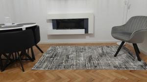 a living room with a table and chairs and a fireplace at Helen Apartament in Craiova