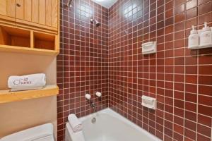 y baño con bañera, aseo y azulejos rojos. en The Charter at Beaver Creek D375, en Beaver Creek