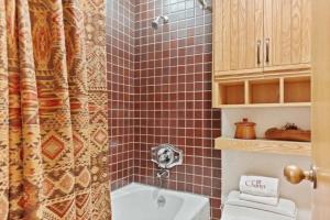 Un baño con ducha con una cabeza de perro en la pared. en The Charter at Beaver Creek D415, en Beaver Creek 6 fotos más