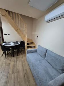 a living room with a couch and a table and stairs at Apartament Exclusive Premium Sielpia w Sielpi Wielkiej z jacuzzi na życzenie in Sielpia Wielka