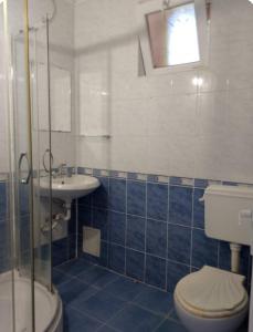 a blue tiled bathroom with a toilet and a sink at Wild house Goriza in Goritsa