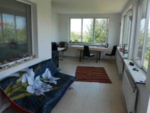 a living room with a couch and a table with windows at Wild house Goriza in Goritsa