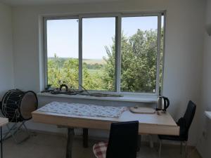 a room with a table and two large windows at Wild house Goriza in Goritsa +5 photos