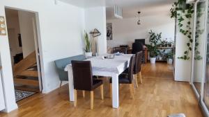 una sala da pranzo con tavolo e sedie bianchi di Villa avec piscine By Platinum Homes- capacité 8 personnes - Heillecourt a Heillecourt Altre 3 foto