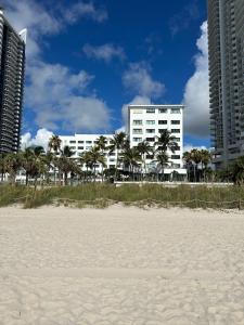 een wit gebouw op het strand met palmbomen bij Casablanca on the beach in Miami Beach