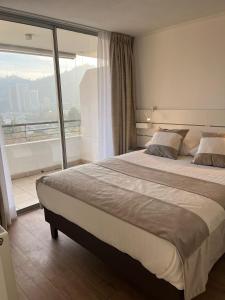 a bedroom with a large bed and a large window at Apart Lyon Suite in Santiago