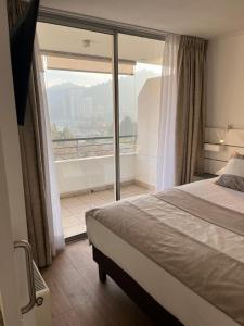 a bedroom with a bed and a large window at Apart Lyon Suite in Santiago