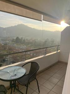 a balcony with a table and chairs and a large window at Apart Lyon Suite in Santiago