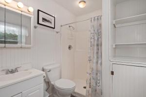 een witte badkamer met toilet en douche bij SNH448 L'il Seabreeze in Nags Head +26 foto's