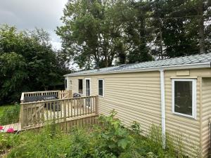 a small house with a wooden deck in a yard at Wild Atlantic Way Stay Carrigart in Donegal