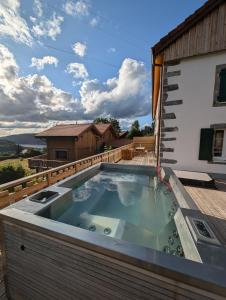 un bain à remous sur la terrasse d'une maison dans l'établissement La ferme de la Rayée 1869, à Gérardmer