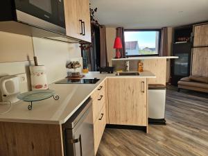 a kitchen with wooden cabinets and a counter top at Studio cosy in Veyrins