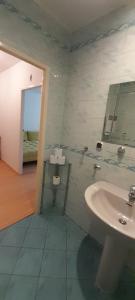 a bathroom with a sink and a mirror and a bed at Apartament w centrum Pobierowa blisko plaży in Pobierowo +7 photos