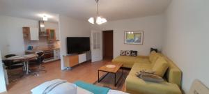 a living room with a couch and a table and a kitchen at Apartament w centrum Pobierowa blisko plaży in Pobierowo