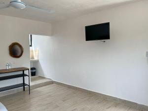 a living room with a tv on a white wall at 3B Departamentos in Tizimín