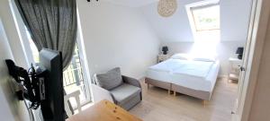 a small bedroom with a bed and a chair at Domek na Błotach in Karwieńskie Błoto Drugie +8 photos