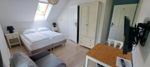 a small living room with a bed and a table at Domek na Błotach in Karwieńskie Błoto Drugie