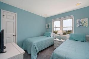 een blauwe slaapkamer met 2 bedden en een raam bij SNH249 SeaAira in Nags Head