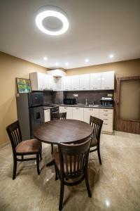 a kitchen with a table and chairs in a room at Апартамент за гости НЕЛИТА in Varshets