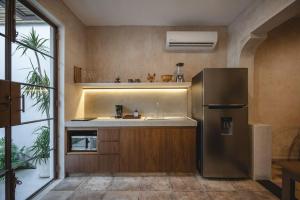 a kitchen with a stainless steel refrigerator and a sink at Itinerante/Casa del Mago. Mérida in Mérida