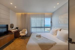 a bedroom with a large bed and a television at Jewel TLV Hotel in Tel Aviv