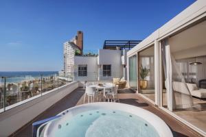 a hot tub on a balcony with a view of the ocean at Jewel Boutique Hotel by The Beach in Tel Aviv