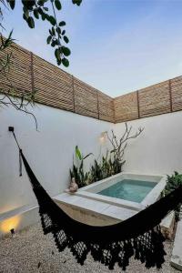 a hammock next to a building with a swimming pool at Itinerante/Casa del Mago. Mérida in Mérida