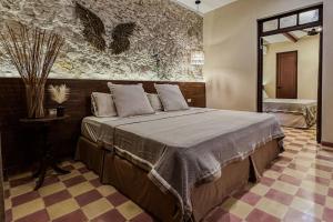 a bedroom with a large bed in a room at Itinerante/Casa del Mago. Mérida in Mérida