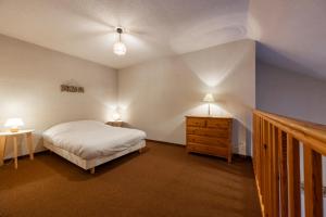 a bedroom with a bed and a nightstand and two lamps at Rive Tranquille - WIFI - Parking - Plan d'eau in Jausiers