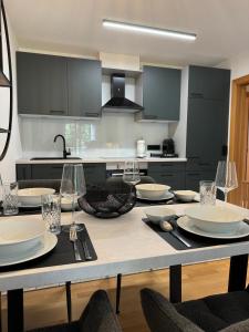 a kitchen with a table with plates and wine glasses at Öhlers Prime Suite in Vipiteno