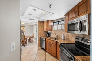 a kitchen with a sink and a stove top oven at Caprice Resort 305 in St. Pete Beach